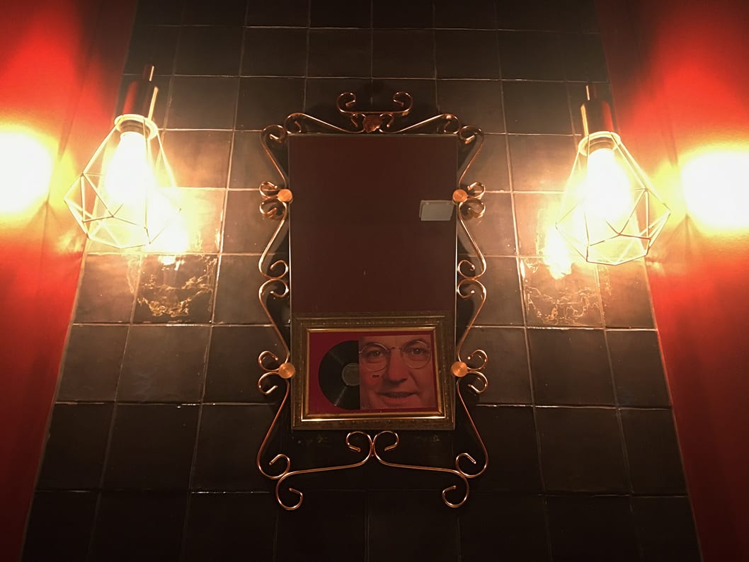 Miroir des toilettes des années 50 avec le reflet de Coluche