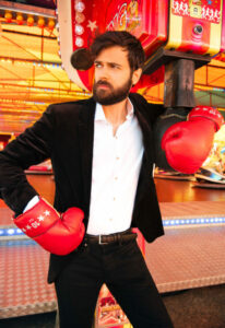 Charles Nouveau en costule de ville, des gants de boxe angalise aux poings