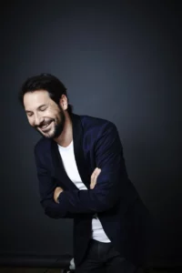 régis Mailhot rit penché en avant