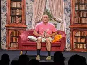Scene de theatre, un personnage, assis sur son canapé