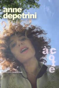Anne de Petrini en portrait sur un fond de ciel bleu et une branche d'arbre très haute. Mention ajoutée : Visuel provisoire, affiche à venir.
