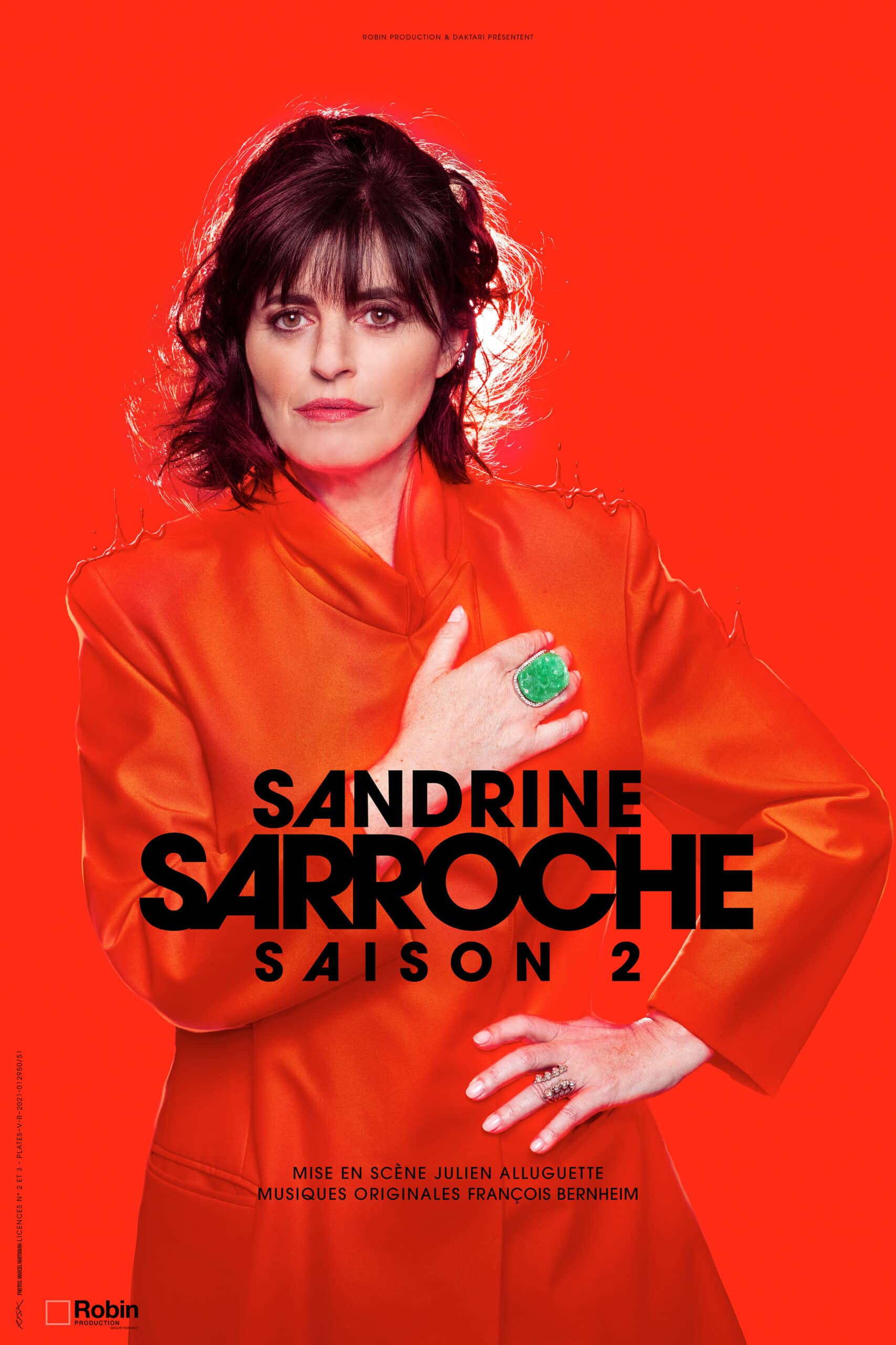 Affriche de Sandrine Sarroche . Portrait d'elle en imper rouge, la main sur le coeur