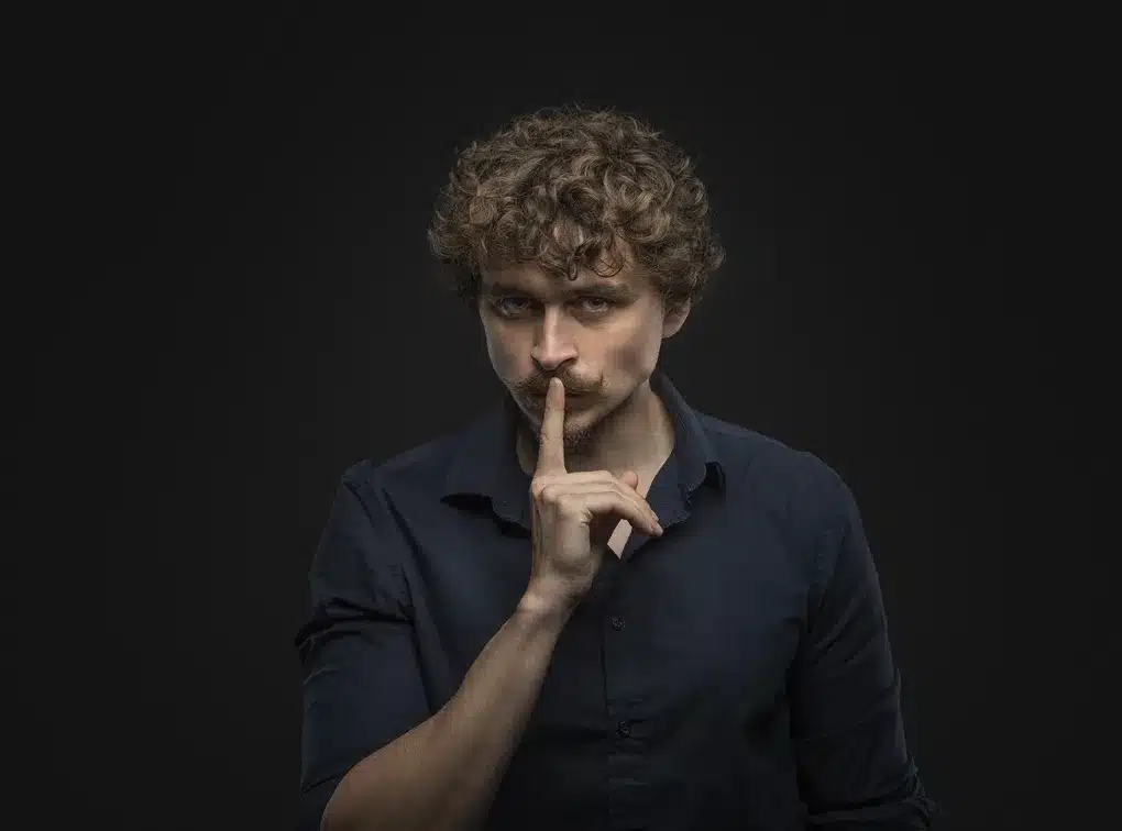Photo de Clément Bonpoil, il tient l'index droit devant sa bouche, ou devant sa moustache