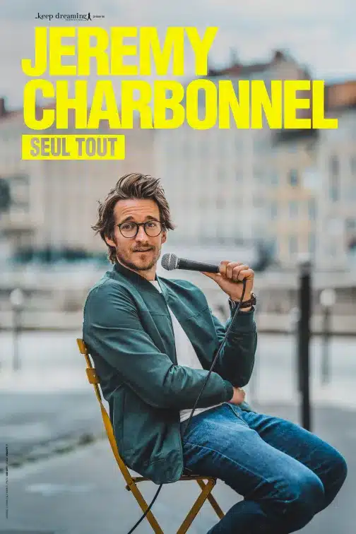 Affiche de "Seul tout", one man show de Jeremy Charbonnel, un micrio à la main, assis sur une chaise en plein air