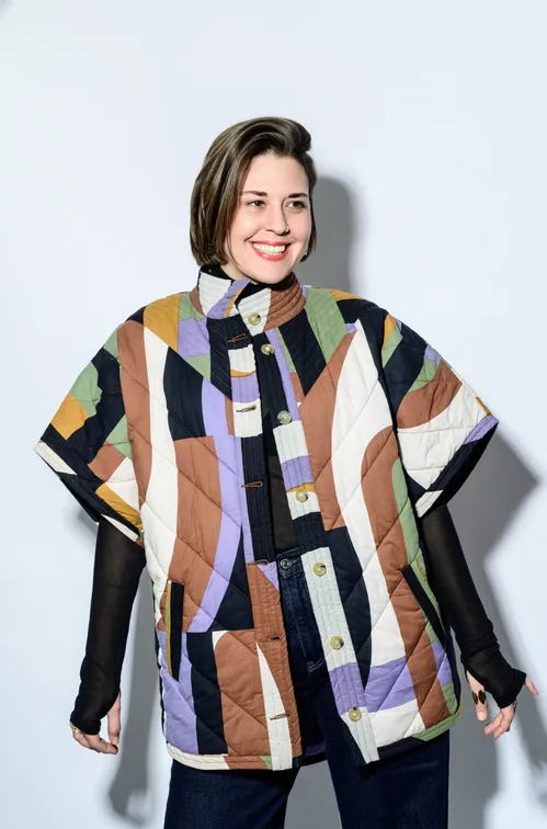 Portrait de Tania Dutel. En veste simili cuir, souriante et de profil
