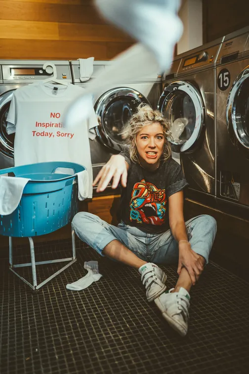 Melodie Fontaine assise devant une machine à laver le linge