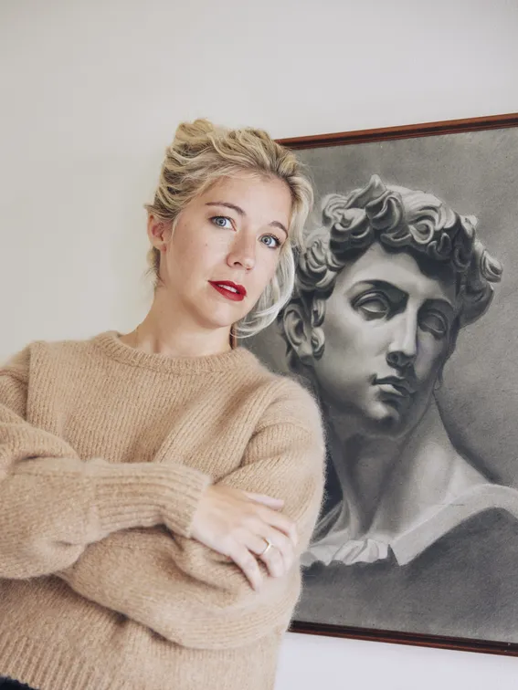 Mélodie Fontaine qui pose devant un tableau au fusain
