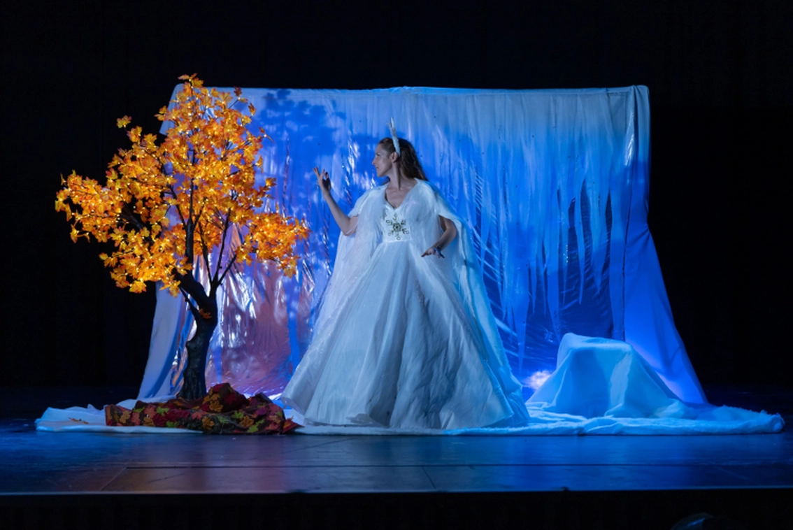 Image de l'hiver, une actrice en robe blanche dans un décor de verre