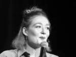 Photo de Anne Cahen dans "Moment de qualité", souriante, parlant au micro