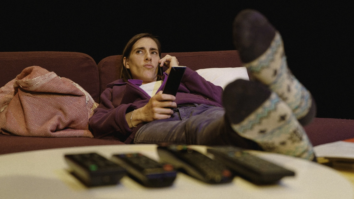 il est au téléphone, allongé sur le canapé,
