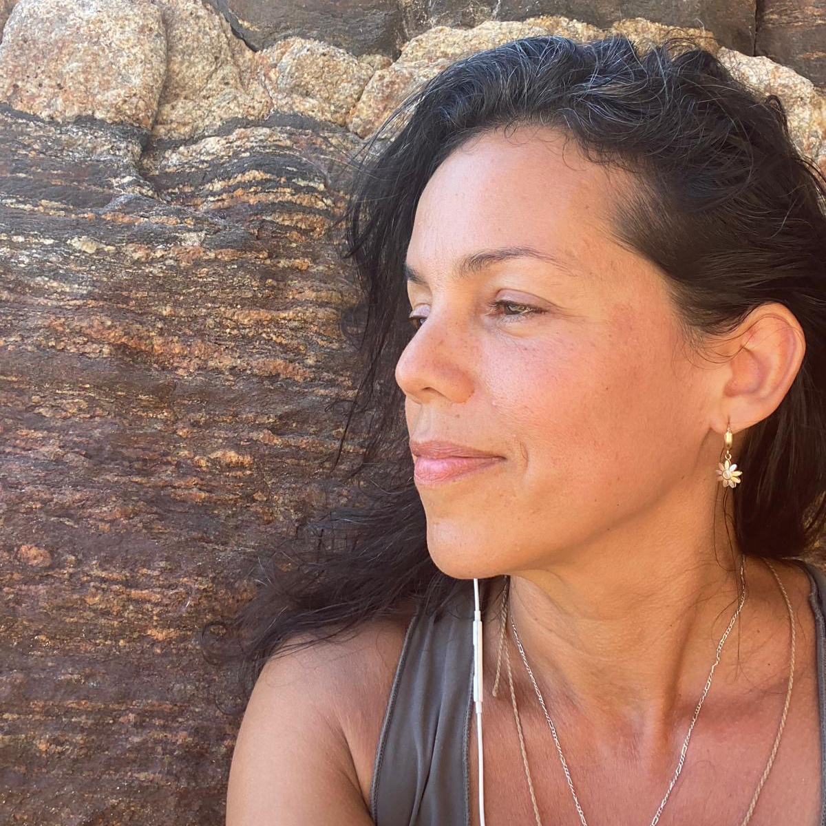 Portrait de Leelama sur fond de pierres, votre professeure de Yoga