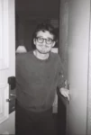 Photo de Cédric, qui vous ouvre la porte de chez lui, avec un sourire figé