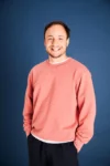Portrait de Thomas GT, souriant et Mains dans les poches