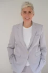 Photo portrait de Marie Bô, de face, souriante, en costume perle