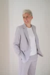 Photo portrait de Marie Bô, de profil, souriante, en costume perle