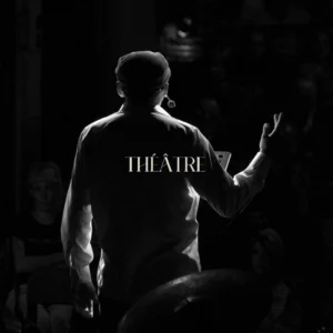 Photo d'un comédien de théâtre, de dos debout et sur scène