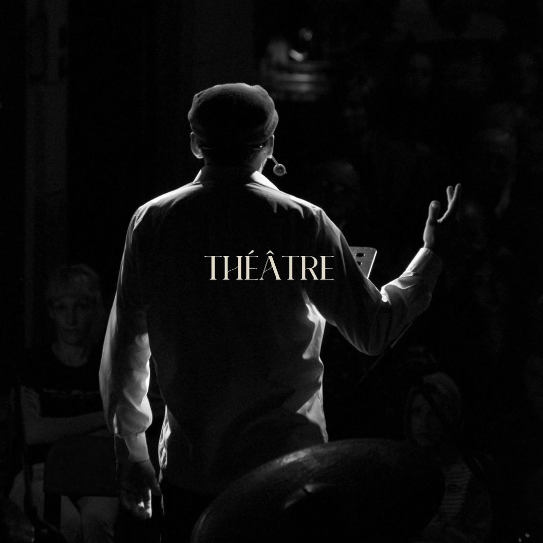 Photo d'un comédien de théâtre, de dos debout et sur scène